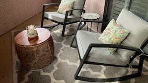 A balcony with two chairs and a round table, each with patterned cushions. - Beautiful pool oasis near TPC Scottsdale (Scottsdale)