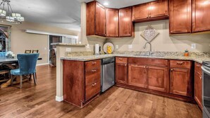 A kitchen with wooden cabinets, a dishwasher, and a granite countertop. - Beautiful pool oasis near TPC Scottsdale (Scottsdale)