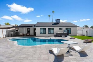 A modern house with a swimming pool, patio furniture, and a covered outdoor area. - Exclusive 3BR: Pool, hot tub, BBQ grill (Mesa)