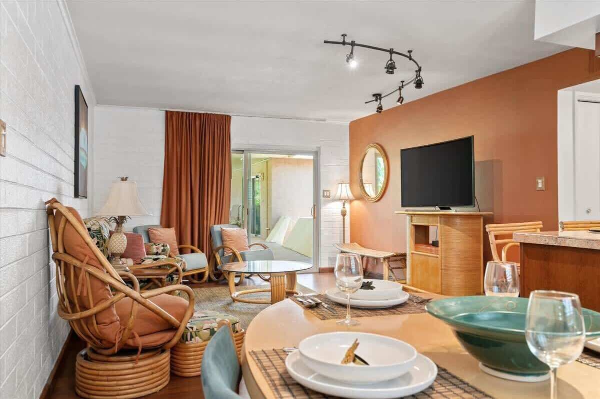 Ein modernes Hotelzimmer mit Essbereich, Fernseher und großem Fenster.