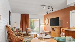 Ein modernes Hotelzimmer mit Essbereich, Fernseher und großem Fenster.