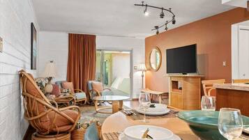 Ein modernes Hotelzimmer mit Essbereich, Fernseher und großem Fenster.