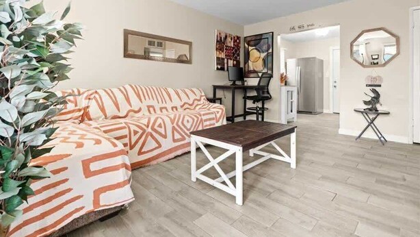 A modern living room with a sofa, a coffee table, and a desk with a computer. - Exclusive BBQ oasis, mins to Papago Park (Phoenix)