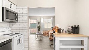 A compact kitchen with white appliances, a wooden countertop, and a view to a balcony. - Exclusive BBQ oasis, mins to Papago Park (Phoenix)