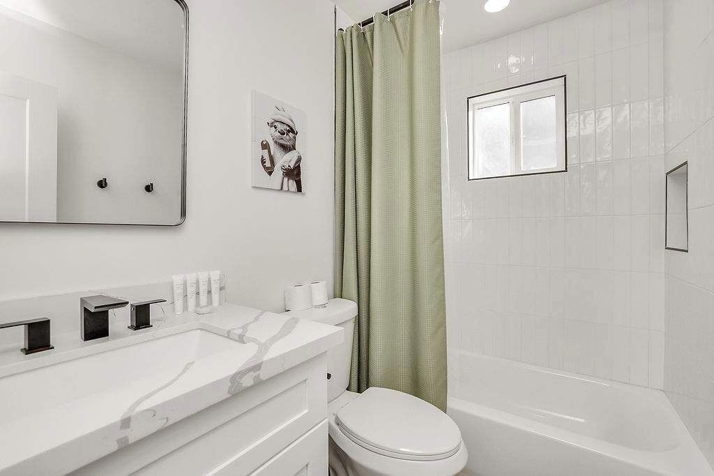 Une salle de bain moderne avec un meuble-lavabo blanc, des toilettes et une baignoire.
