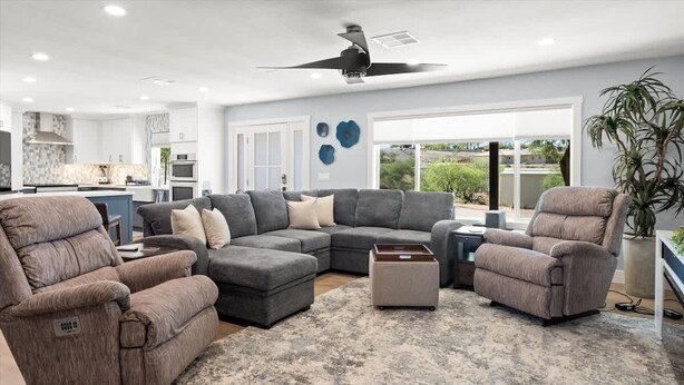Ein modernes Wohnzimmer mit einem Ecksofa, zwei Relaxsesseln und einem Couchtisch.