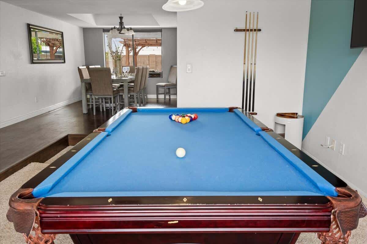 A pool table with a blue felt surface, surrounded by a wooden frame.
