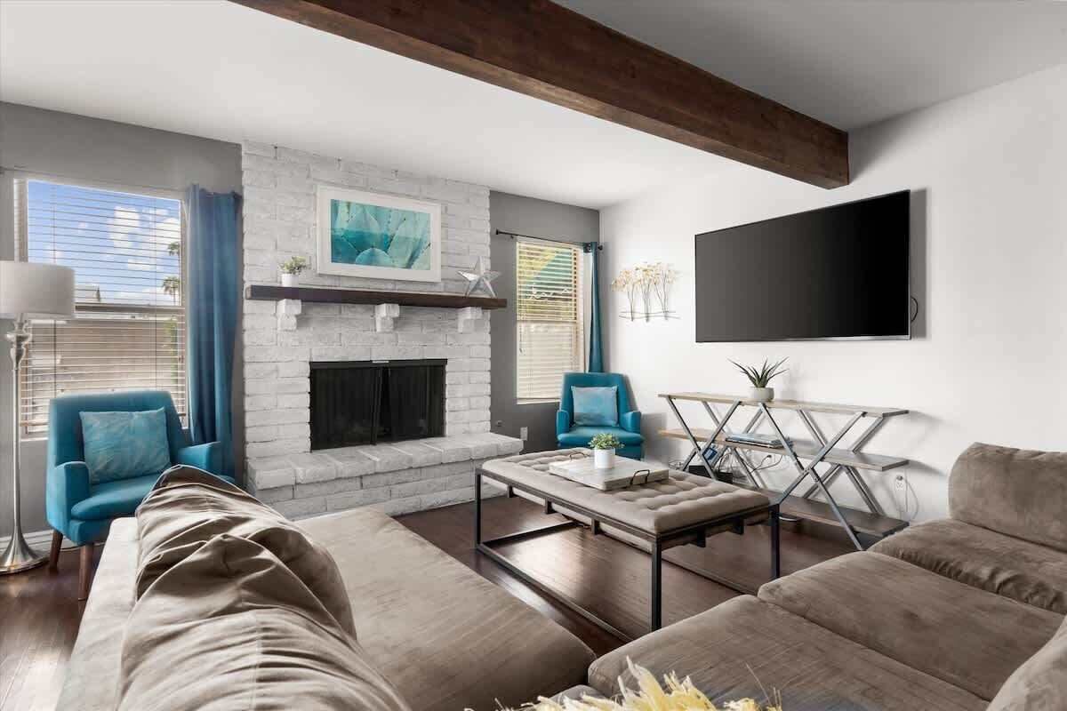 A modern living room with a fireplace, a flat-screen TV, and comfortable seating.