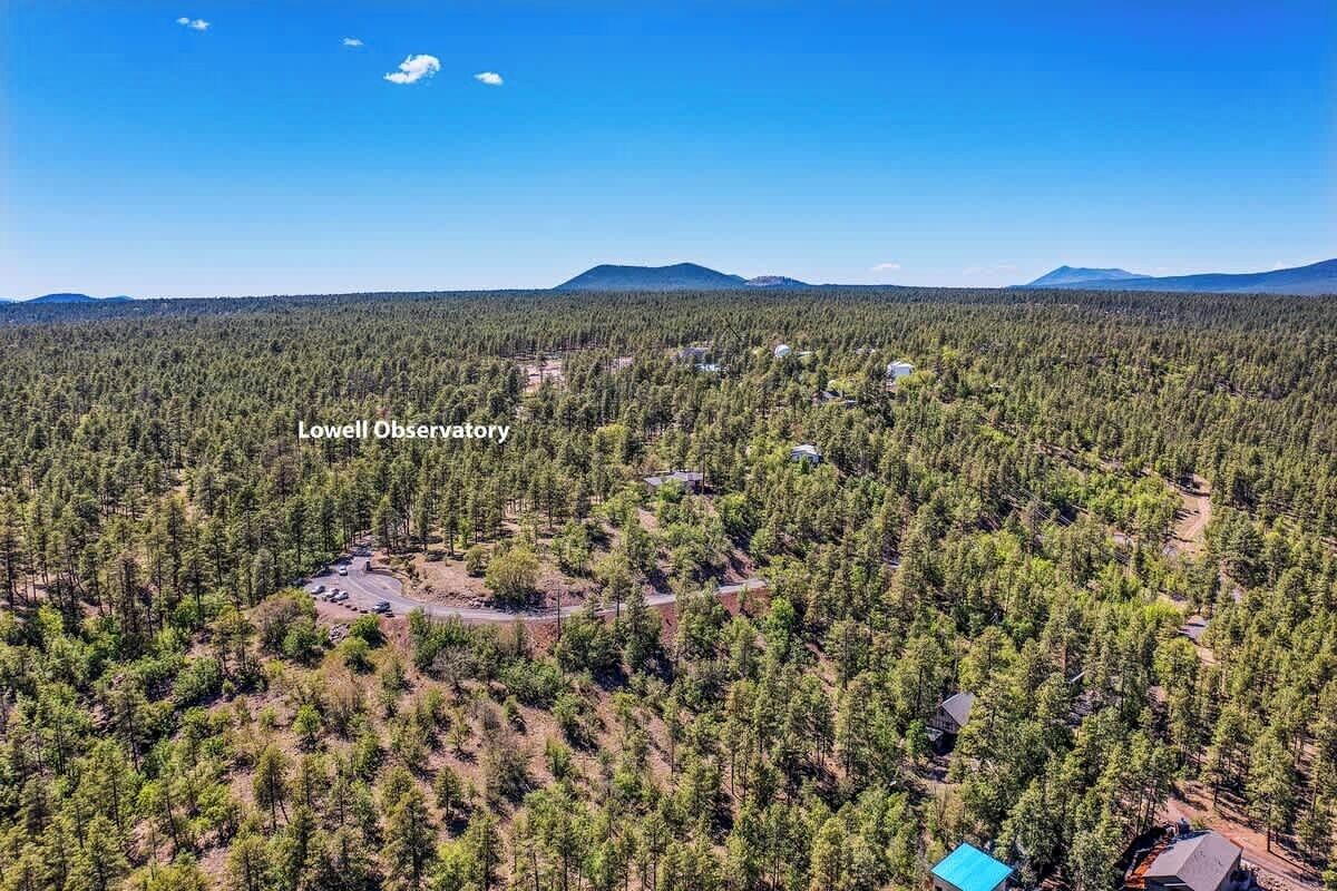 Vista aérea de una zona boscosa con un pequeño grupo de edificios identificados como 'Lowell Observatory'.