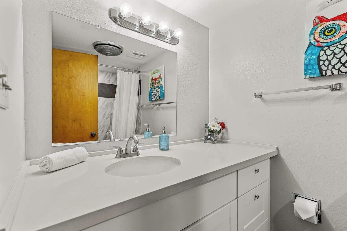 A bathroom with a white sink, mirror, and towel.