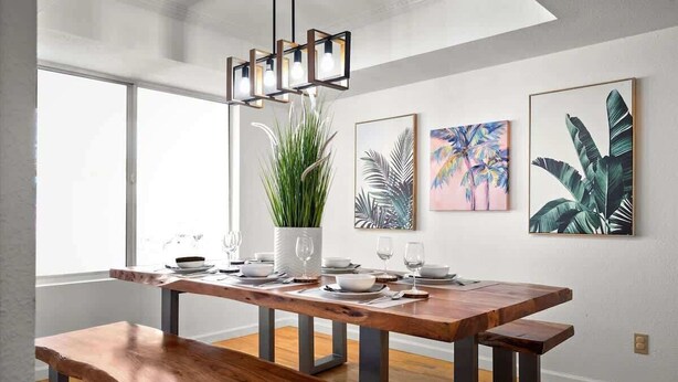A modern dining area with a wooden table, benches, and a hanging light fixture. - Private pool + fire pit · Moon Valley retreat (Phoenix)