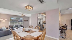 A modern living room with a dining table, sofas, and a kitchen area. - Exclusive Tempe home: pool, BBQ, sleeps 8 (Tempe)