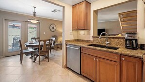 A modern kitchen with granite countertops, wooden cabinets, and a built-in oven. - Exclusive 3BR Retreat, Pool & Spa Access (Scottsdale)