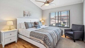 A bedroom with a bed, nightstand, chair, and a ceiling fan. - Exclusive 3BR Retreat, Pool & Spa Access (Scottsdale)