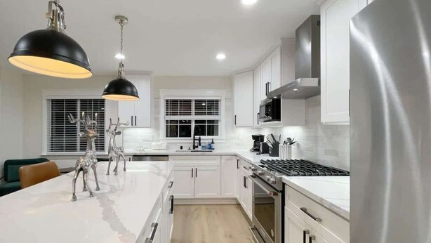 A modern kitchen with white cabinetry, stainless steel appliances, and pendant lighting. - Marbella Lane - Contemporary Sophisticated Home (Sunnyvale)