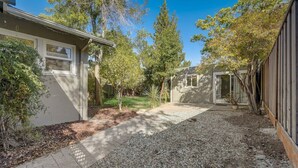 A residential property with a gravel driveway, a small garden area, and a wooden fence. - Marbella Lane - Cozy 1BR in Palo Alto DWNTN Hub (Palo Alto)