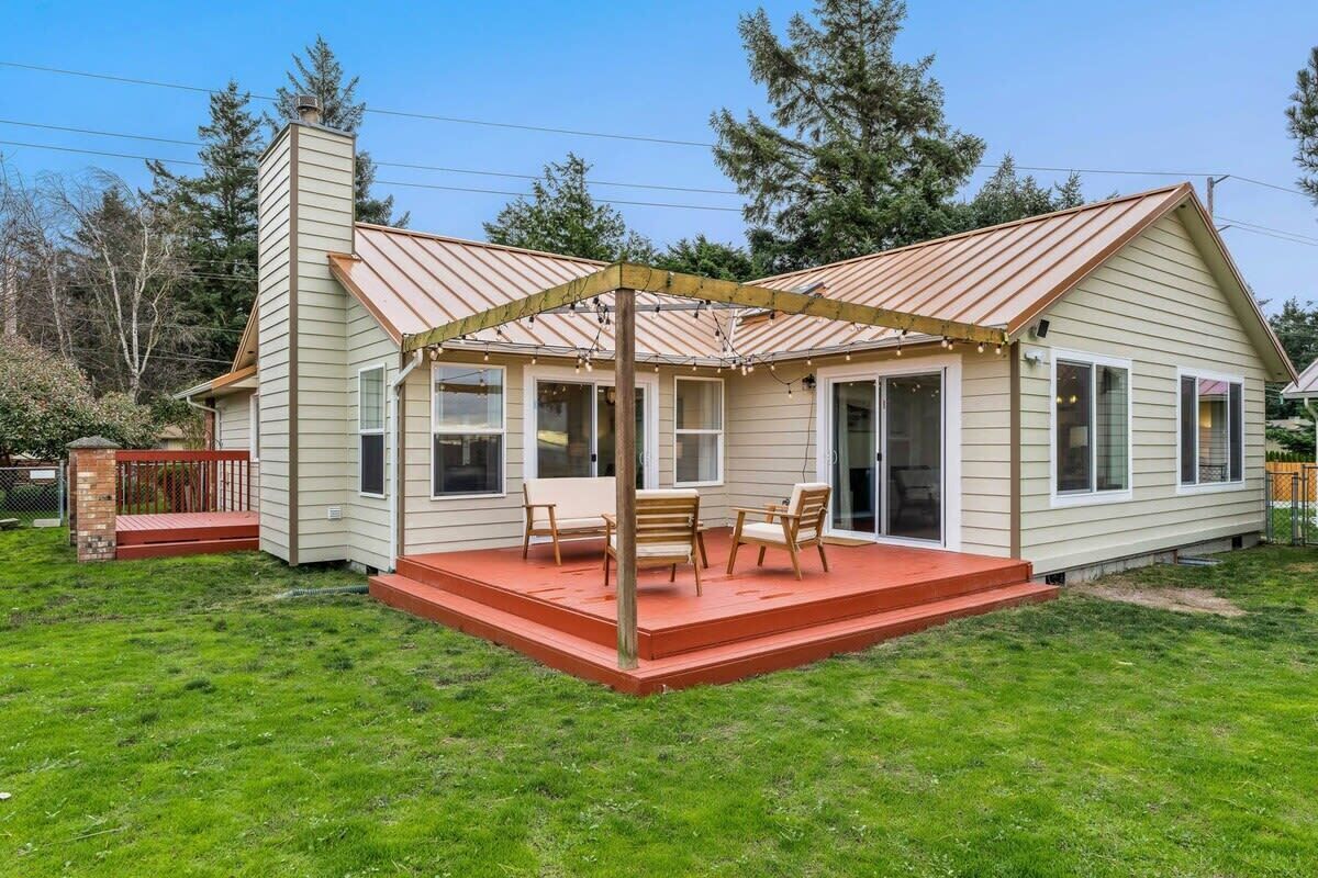 A single-story house with a covered patio area, a chimney, and a fenced yard.