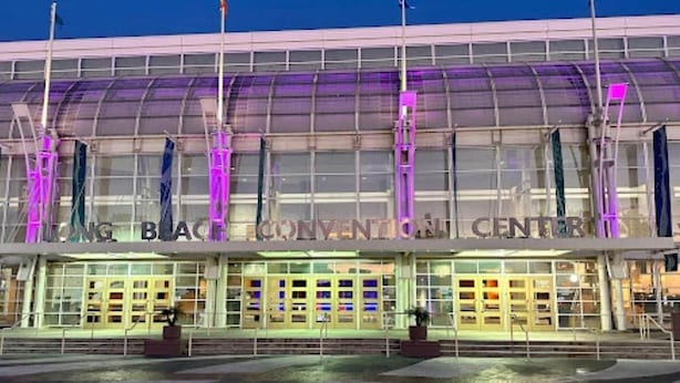 Ein Kongresszentrum mit einer großen Glasfassade und einem überdachten Eingangsbereich.
