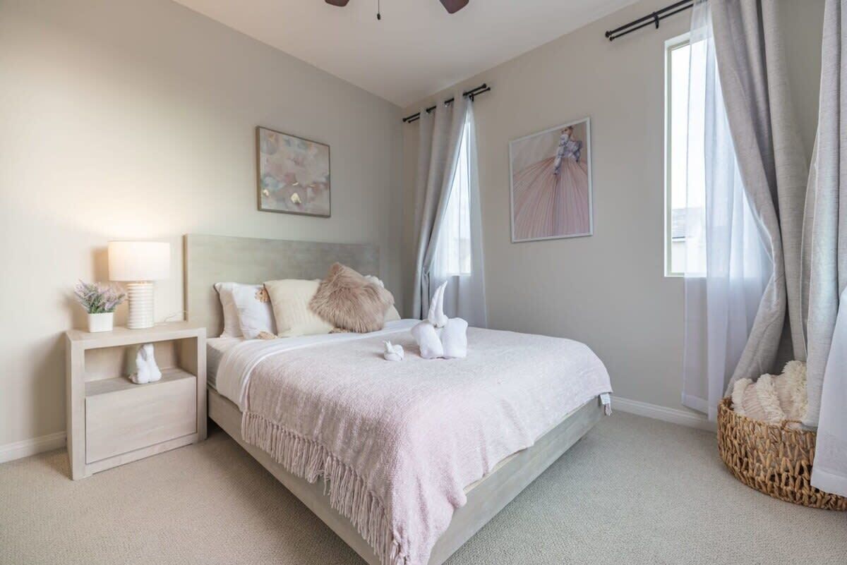 A bedroom with a bed, bedside table, and a window with curtains.