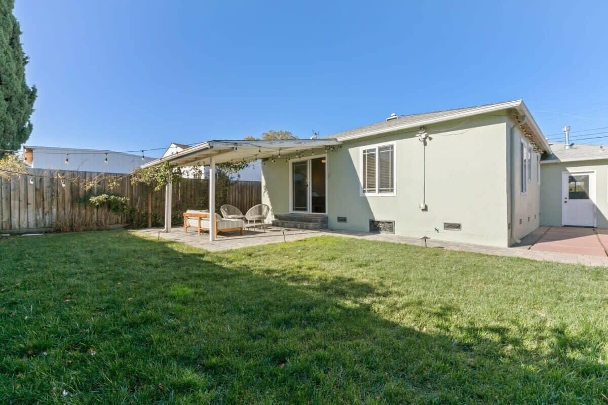 A single-story house with a covered patio area, a fenced backyard, and a front door.