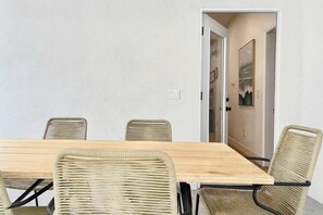 Comedor con mesa de madera y cuatro sillas de mimbre.