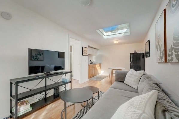 Ett modernt vardagsrum med en soffa, en tv och ett litet matbord.