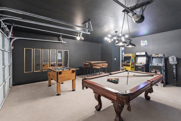 Ein Raum mit Billardtisch, Kicker und Spielautomaten.