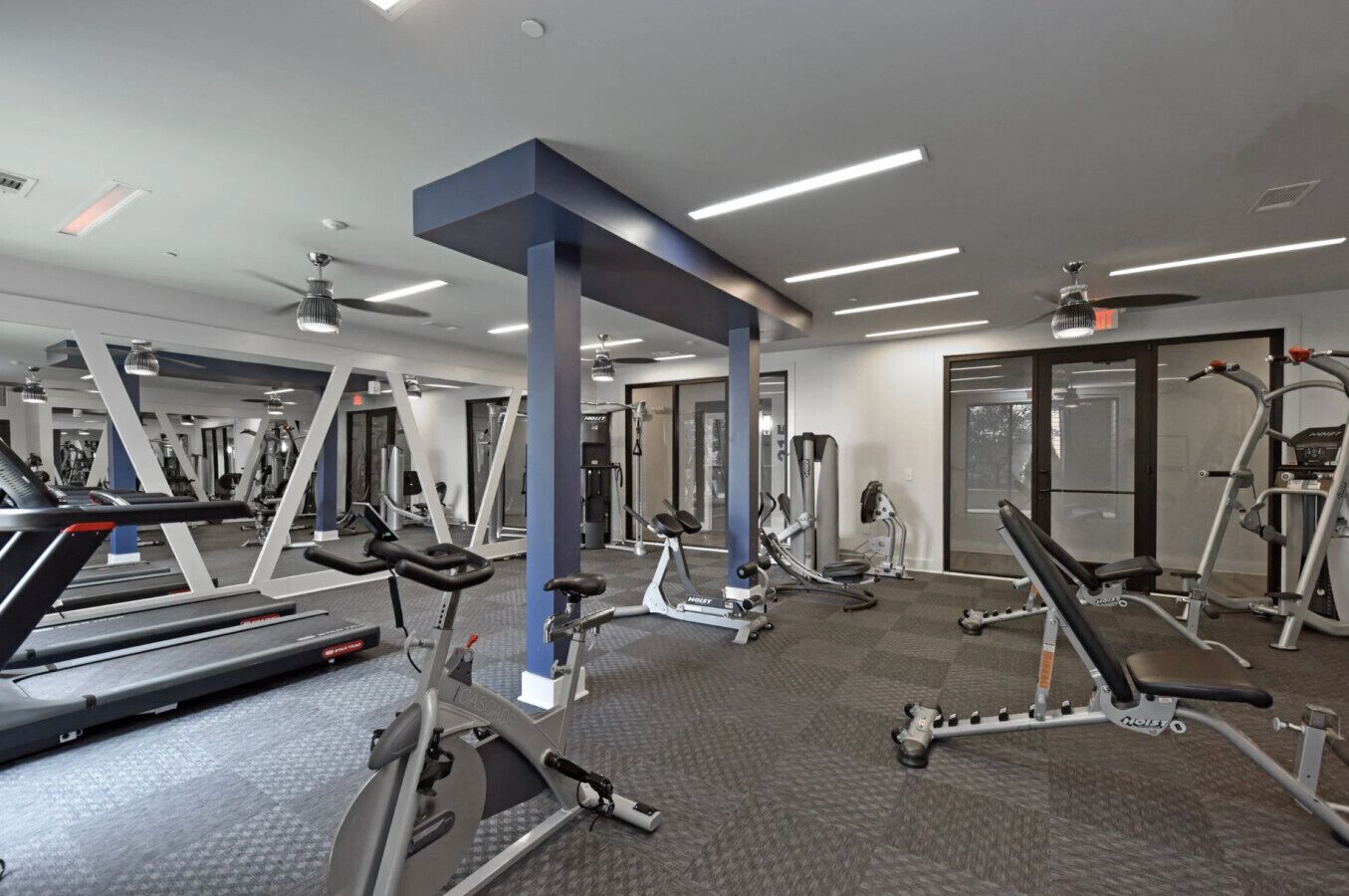 A gym with treadmills, elliptical machines, and weight equipment.