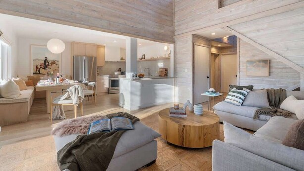 A spacious living area with a high ceiling, a dining area, and a kitchen.