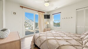 Ein Schlafzimmer mit einem Bett, einem Nachttisch, einem Fernseher und einem Fenster mit Jalousien.