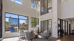 Eine geräumige Lobby mit großen Fenstern, hoher Decke und modernem Design.