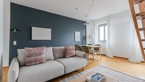 Un salon moderne avec un canapé, une table à manger et un escalier.