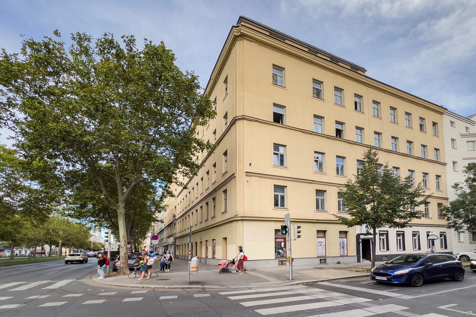 Un immeuble à plusieurs étages doté d’une façade sobre, de grandes fenêtres et d’un passage piéton.