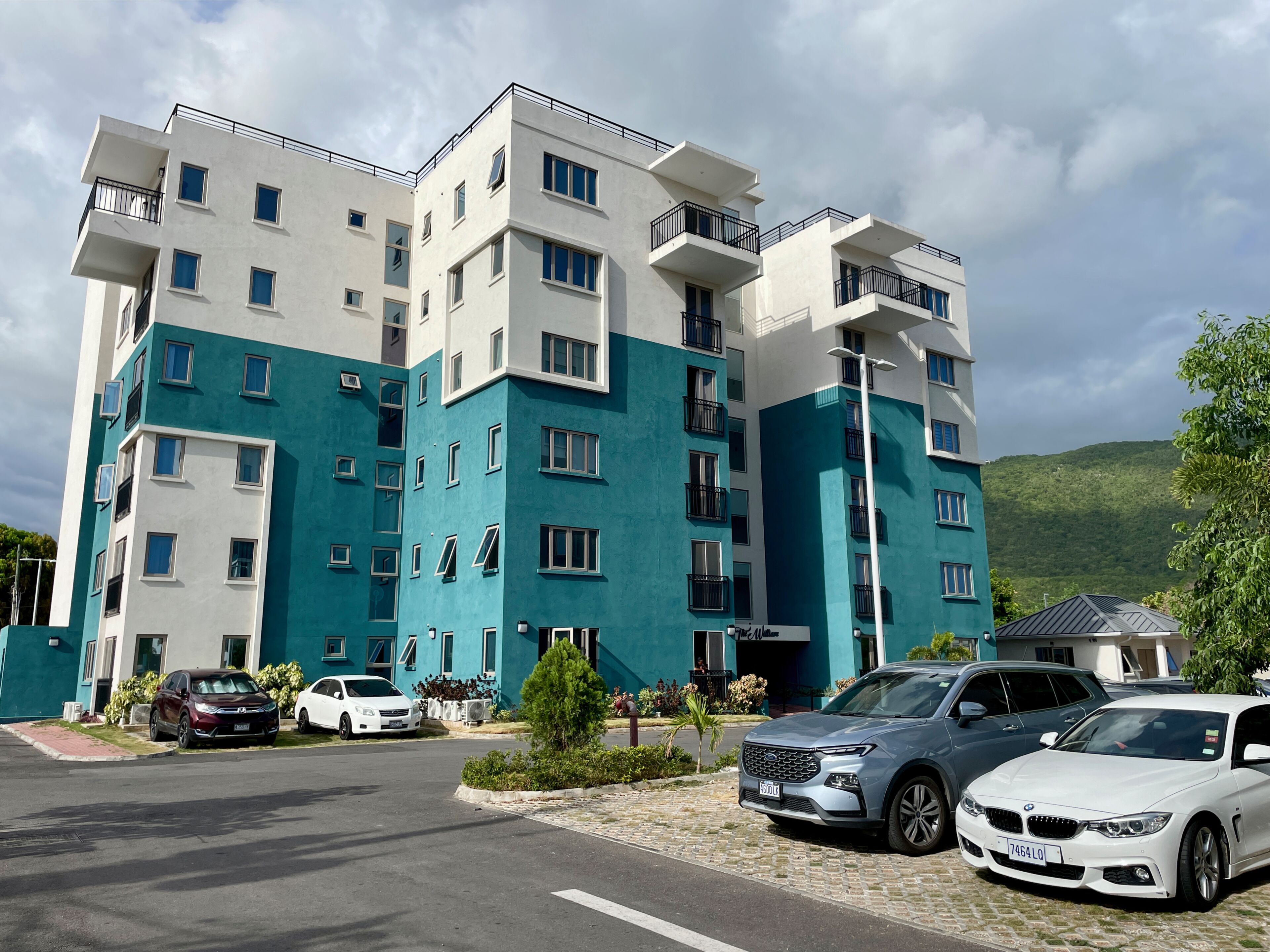 Un immeuble résidentiel à plusieurs étages avec un espace de stationnement à l’avant.