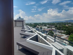 A rooftop terrace with a view of the cityscape and mountains. - Charming 1 Bedroom Apartment Unit in the Heart of The City. (Kingston)