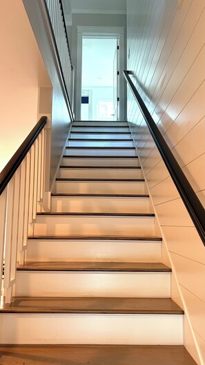 A staircase with white walls and wooden steps leading to a door at the top. - - Luxury Santa Rosa Beach Retreat, Hot Tub, Sauna, putting Green, Sleeps 9 (Santa Rosa Beach)