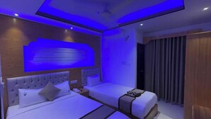A modern hotel room with a large bed, a smaller bed, and a seating area. - Hotel Amin International Cox's Bazar (Cox's Bazar)
