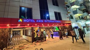 A hotel entrance with a red awning and a sign reading "HOTEL AMIN INTERNATIONAL". - Hotel Amin International Cox's Bazar (Cox's Bazar)