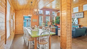 Un int érieur en bois comprenant un coin repas, une cuisine et une enseigne indiquant : « LOCATION DE BOVIN, TOUS LES VENDREDIS ».