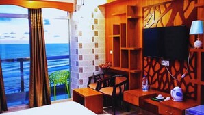 A hotel room with a balcony, wooden decor, a TV, and a bed.