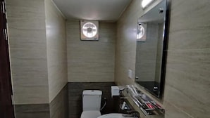 A modern bathroom with a toilet, sink, and mirror.