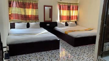 Habitación de hotel con dos camas, un espejo y cortinas estampadas.