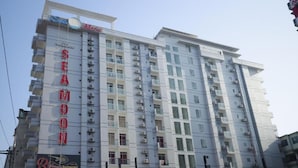 A multi-story hotel with a prominent 'SEA' sign on the facade, indicating a seaside location.