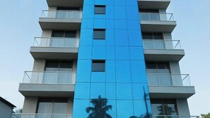 Ein modernes Hotel mit blauer Fassade und einem Schild mit der Aufschrift 'MIAMI BEACH RESORT'.