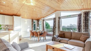 A spacious living area with a wooden ceiling, a dining table with chairs, a sofa, and a coffee table. - Field View 2 bed-No pets-Hornbeam - sleeps 6 guests  in 2 bedrooms (Eye)
