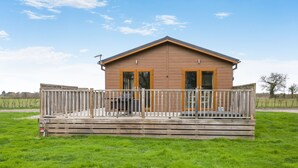 Eine Holzhütte mit einer Terrasse und einer umzäunten Veranda.