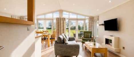 A spacious living area with a sofa, a television, and a dining table.
