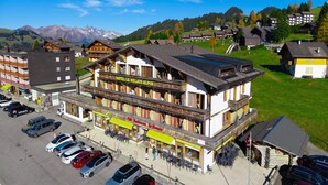 A hotel with a balcony, a restaurant, and a parking lot. - Hotel Relais Alpin Twin Room & Balcony 7 236 summer mode, Les Mosses, Switzerland (Les Mosses)