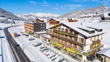 Ein Hotel mit Seilbahn, umgeben von schneebedeckten Bergen und einem klaren Himmel.