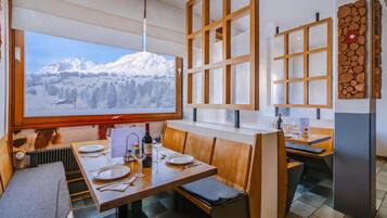 Un restaurant offrant une vue sur la montagne, doté de meubles en bois et d’un présentoir à menus.